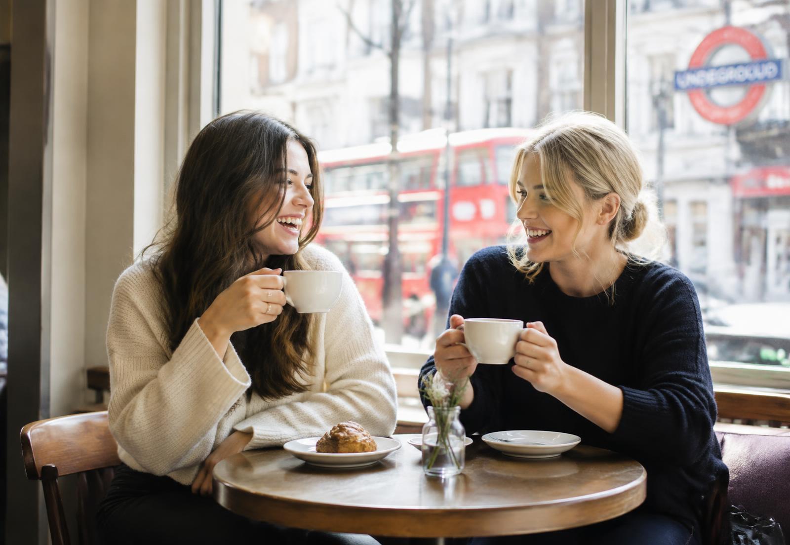 Two friends laughing over coffee